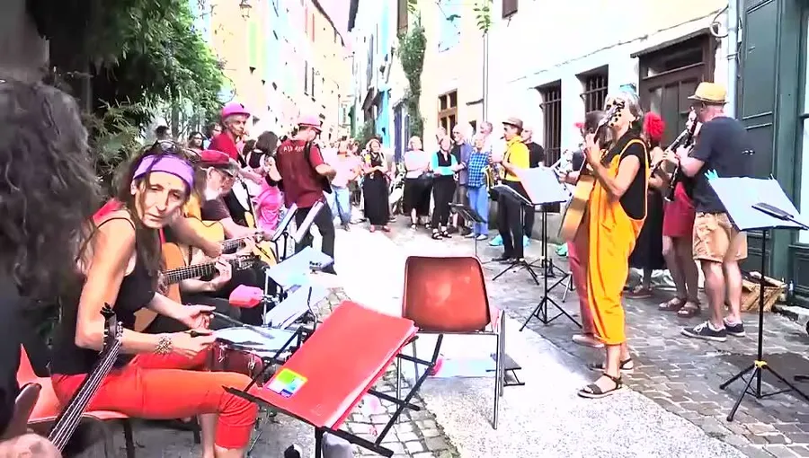 Image du teaser 2026 : la fanfare joue dans une rue en pente